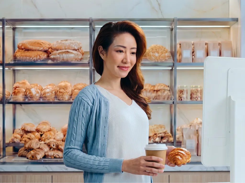 A woman holding coffee in a cafe